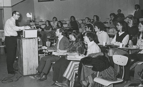 Man teaches a class in a historical photo which appears to be from the 1960s